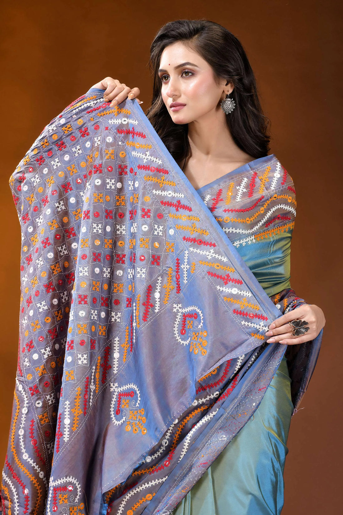 Greyish teal multi-thread ethnic design gujarati stitch dyed silk saree - mirror detailing woman wears vibrant