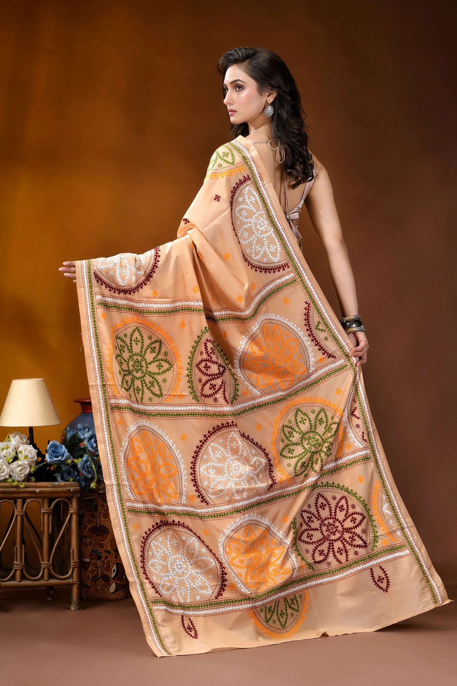 Beige multi-thread floral motif kutch embroidery silk saree woman wears peach-colored saree intricate 5