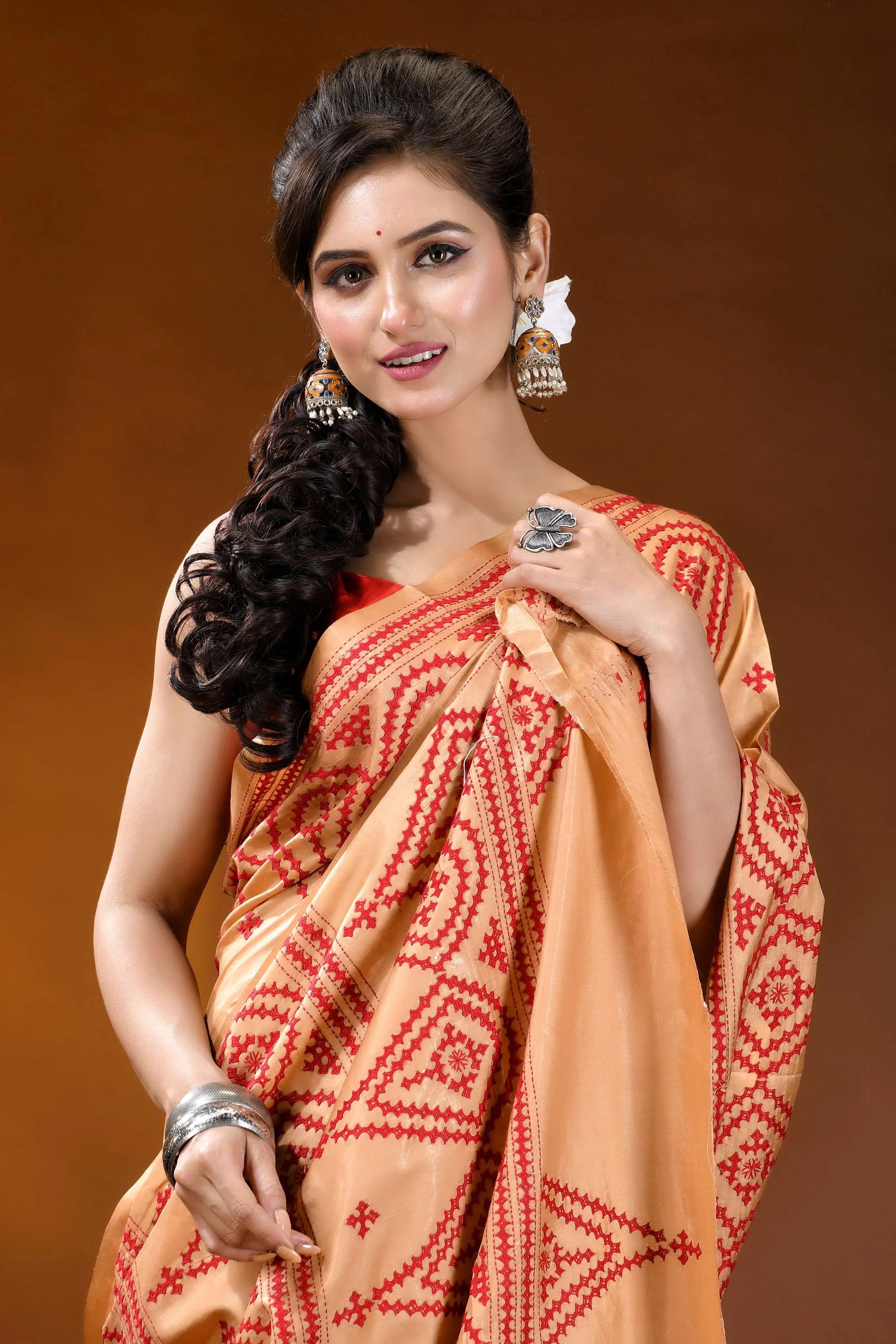 Burning sand ethnic motif hand embroidered silk kutch work saree woman wears peach-colored saree intricate 2