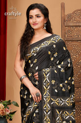 a woman in a black and gold sari
