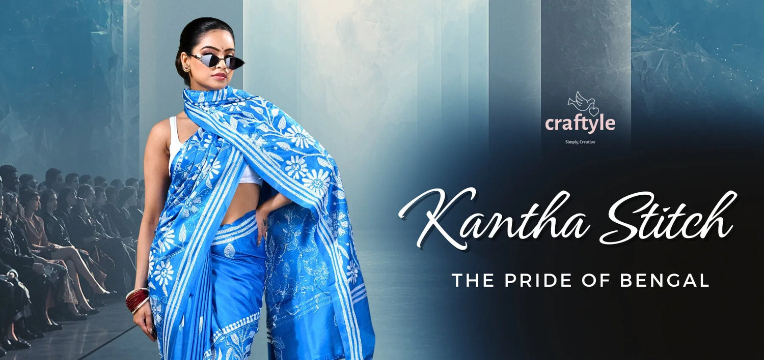 A woman wears a vibrant blue kantha stitch saree with intricate white floral embroidery and bold vertical stripes