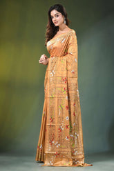 Peach hand embroidered folk art motif kantha embroidery silk saree woman wears golden-orange intricate 3