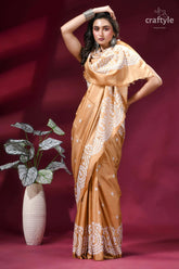 White thread hand gujrati embroidery silk saree in tan color woman wears golden-brown silk saree 5